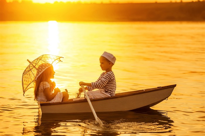 Children in a boat at sunset