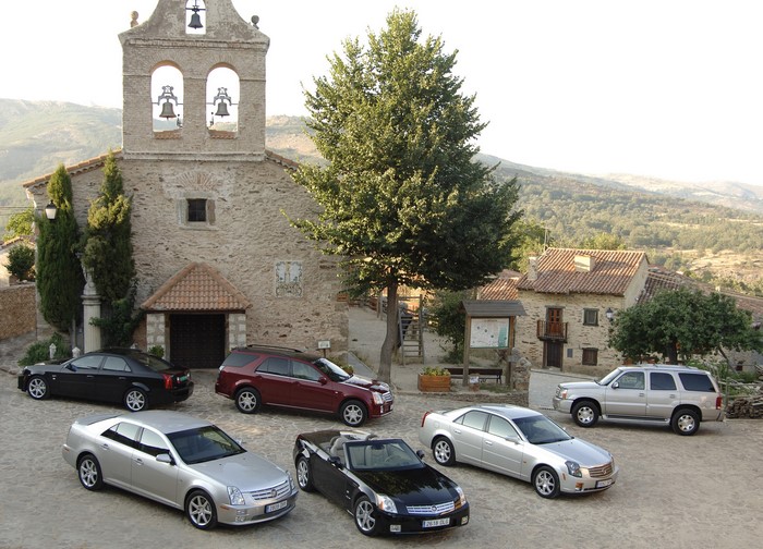 Cadillac cars parked in front of a stone church