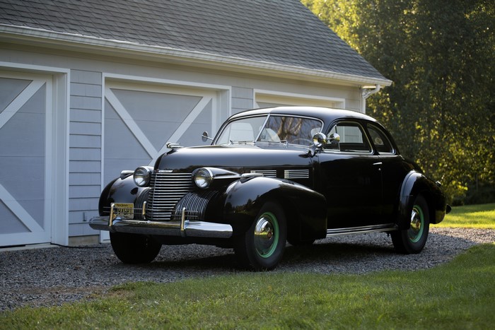 Black 1940 Cadillac Sixty-Two Coupe parked by garage