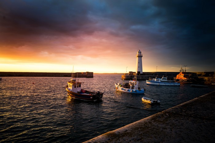 Donaghadee Lighthouse and boats at sunset, Northern Ireland