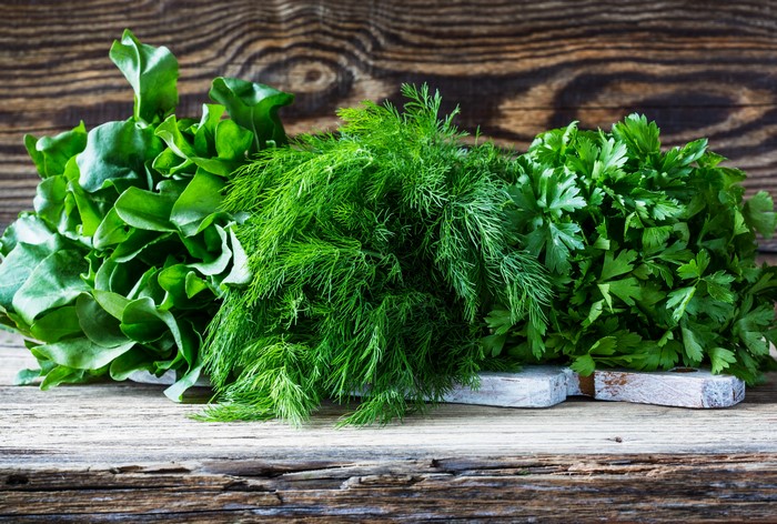 Fresh Dill, Parsley, and Spinach on Wooden Surface