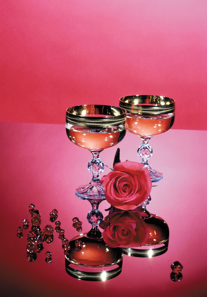 Two champagne glasses with rose and red gems