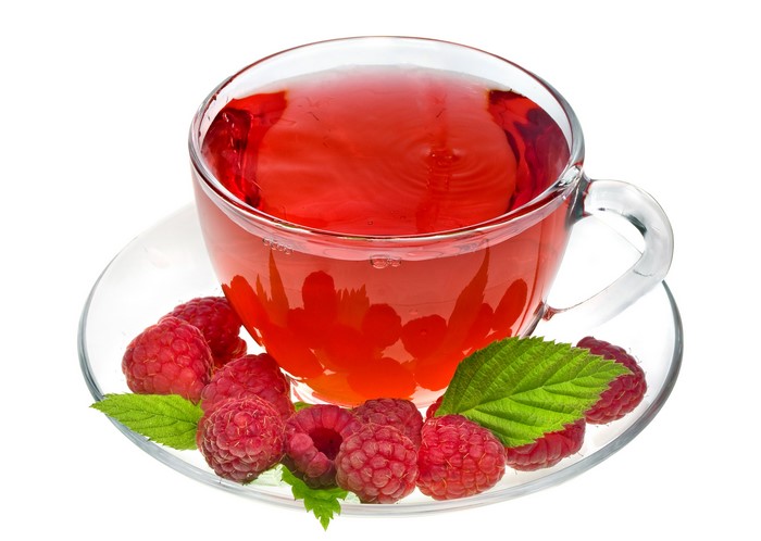 Raspberry tea in a glass cup with fresh raspberries