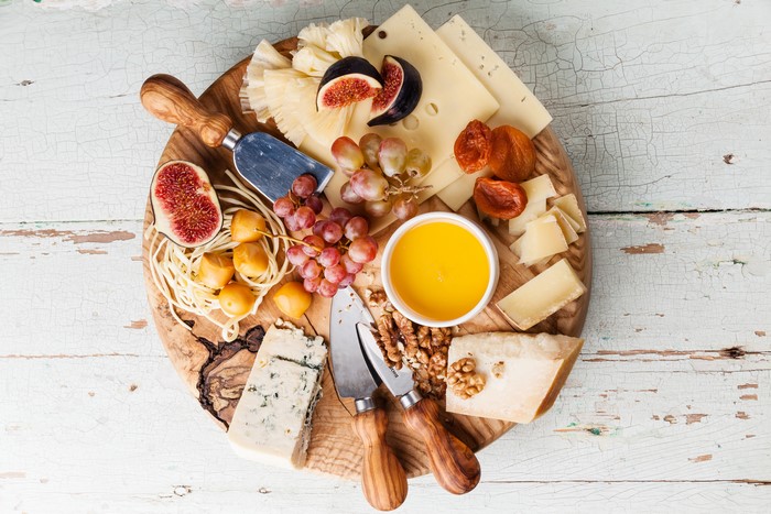 Cheese board with figs, grapes, honey, and nuts