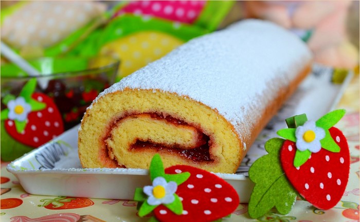 Swiss roll with strawberry jam and powdered sugar