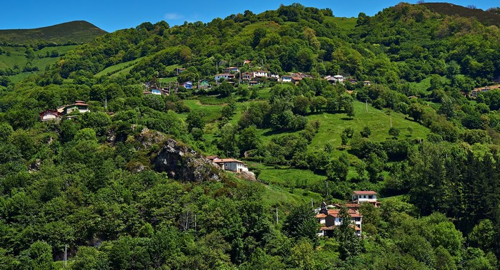 Houses nestled in green hills of Proacina, Asturias, Spain
