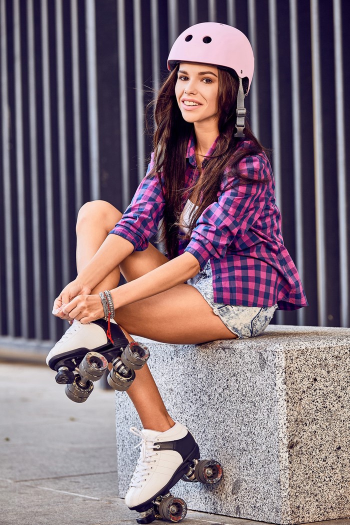 Woman with roller skates and helmet smiling