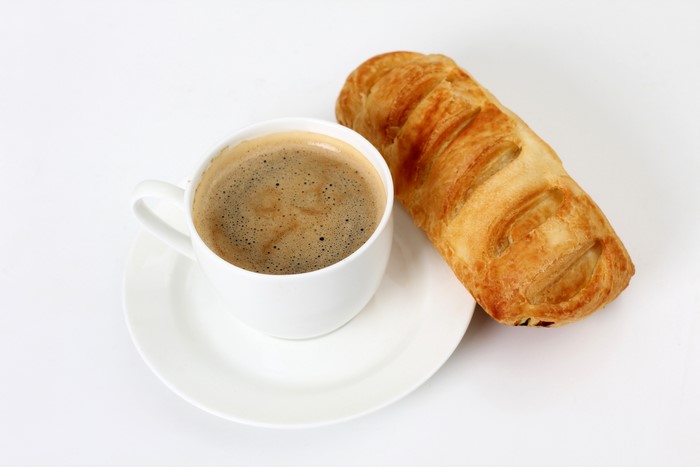 Coffee cup and pastry on white background