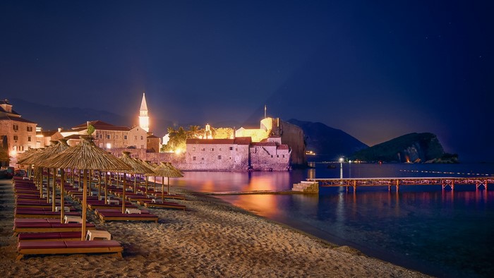 Budva, Montenegro beach at night with old town and pier
