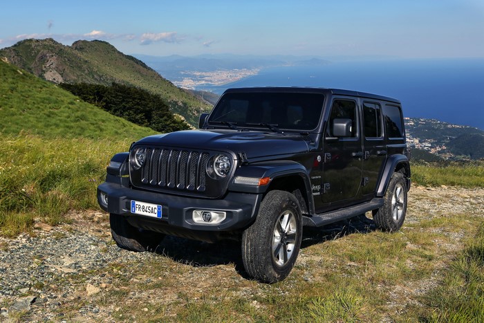 Black Jeep Wrangler Unlimited Sahara on a mountain road