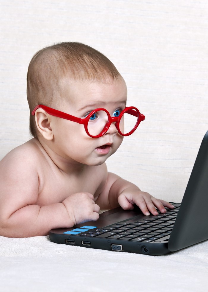Cute Baby in Red Glasses Using Laptop