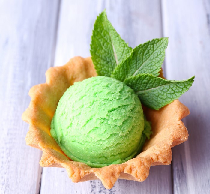 Green ice cream scoop in a tart shell with mint leaves
