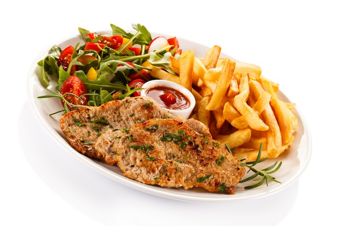 Meat products with french fries and salad on a plate