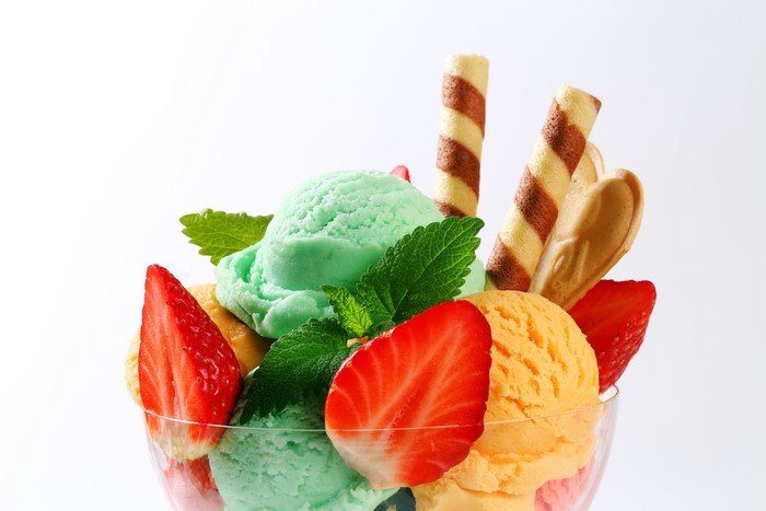Ice cream sundae with strawberries and wafer rolls