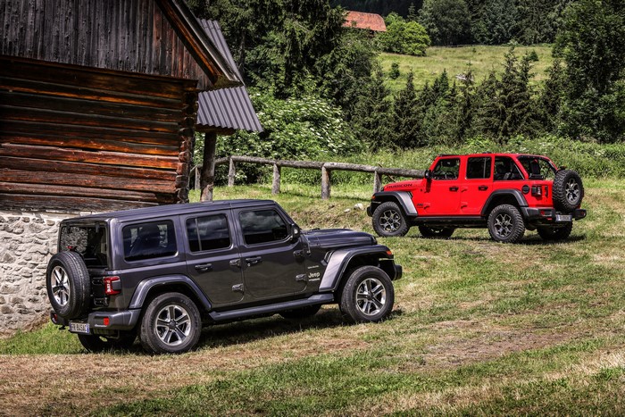 Two Jeep Wranglers near a wooden cabin