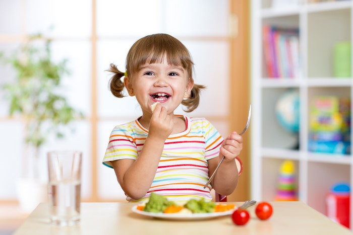 Little girl eating at a table