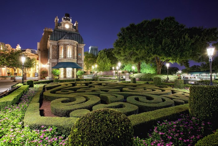 French-style building with a hedge maze at night
