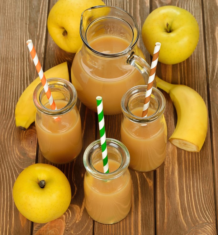 Apple and banana juice in a jug and glasses