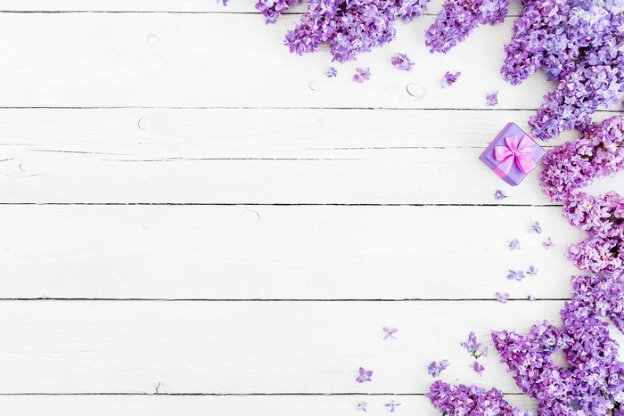 Lilac flowers and gift box on wood planks