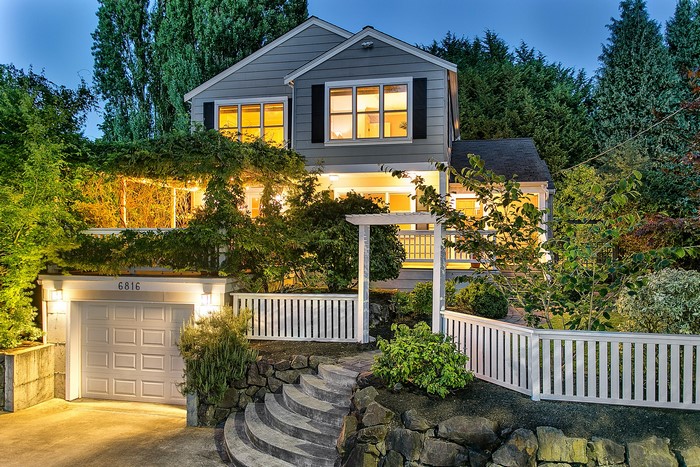 House with garage, stairs, and fence at dusk