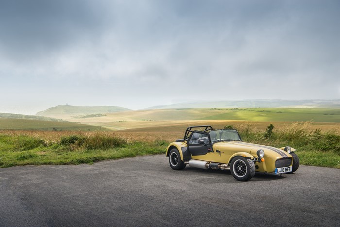 Yellow Caterham 7 420 R on a road with rolling hills
