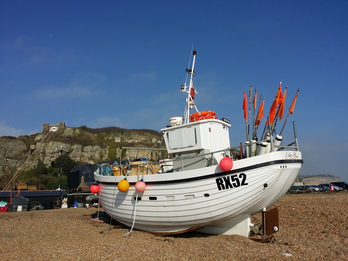 White fishing boat RX52 on a pebble beach