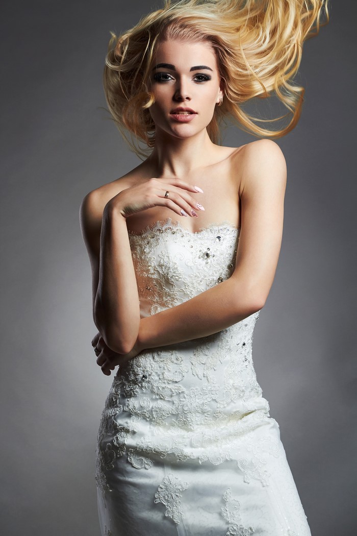 Blonde bride in a white dress with windblown hair