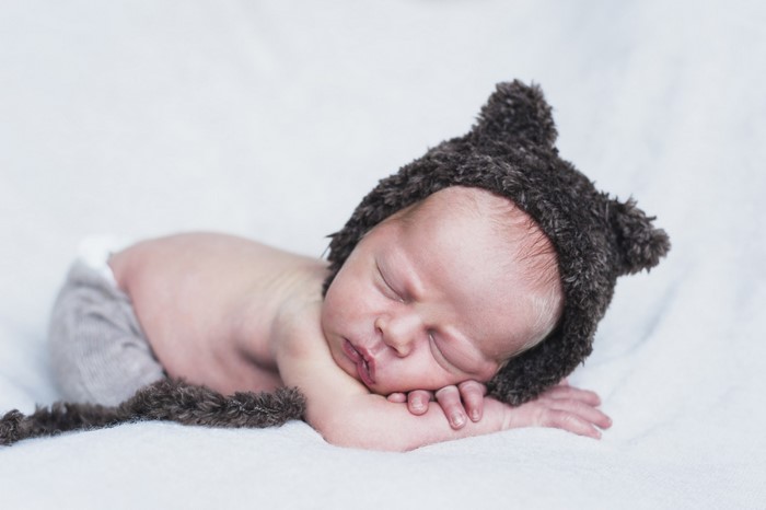Newborn baby sleeping in a bear hat