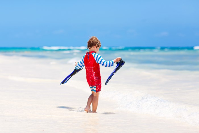 Boy with flippers on a beach
