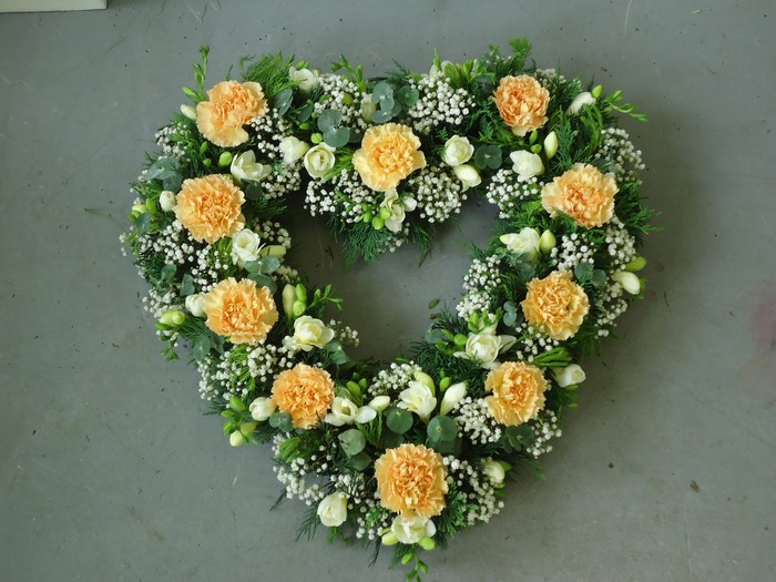 Heart-shaped floral arrangement with carnations and freesia