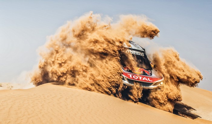 Peugeot rally car driving through sand