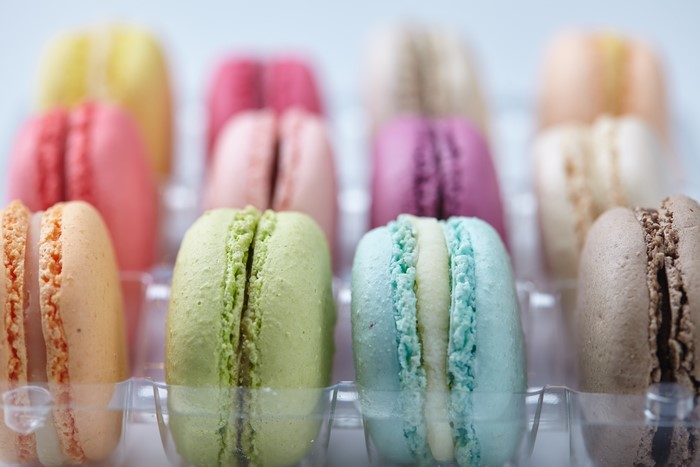 Assortment of colorful macarons in a plastic tray