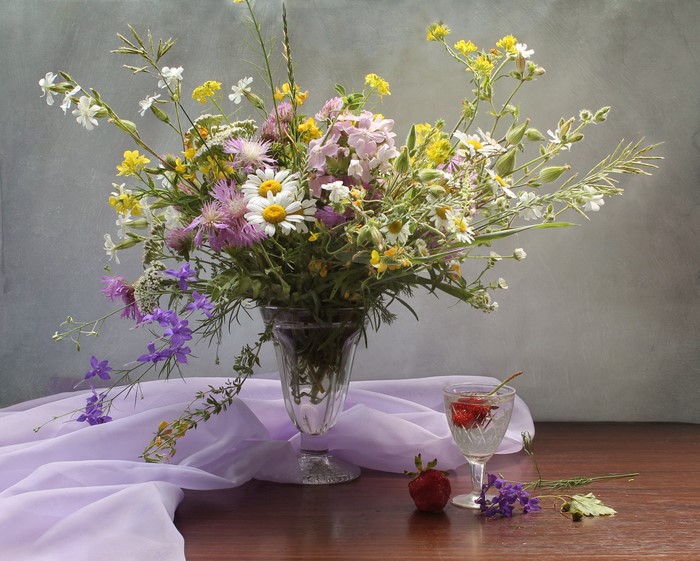 Still-life with wildflowers, strawberries, and a glass of water