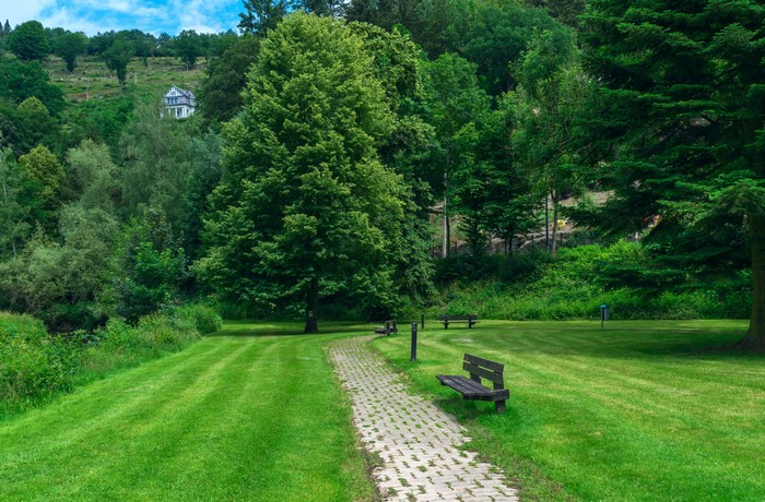Park with benches and trees in Laroche, Belgium