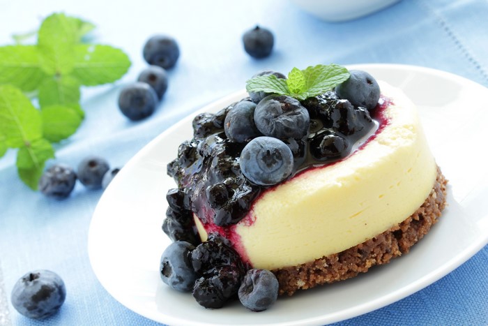 Blueberry cheesecake with mint on a white plate