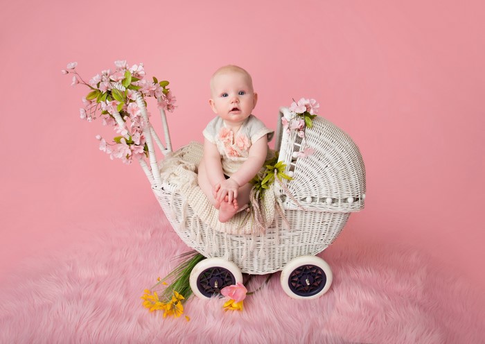 Baby in a vintage pram with flowers