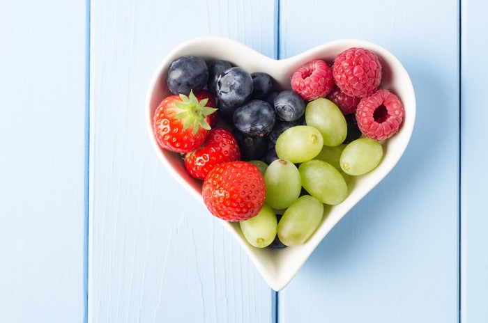 Heart-shaped bowl of berries and grapes
