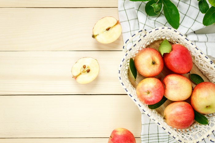 Apples in a basket on wood planks