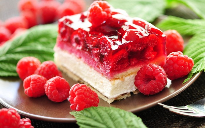 Raspberry cake with fresh raspberries and green leaves