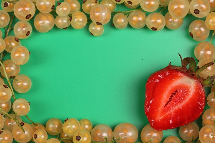 White Currants and Strawberry on Green Background