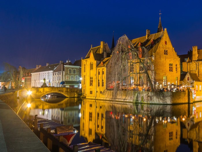 Bruges canal at night with illuminated buildings and bridge