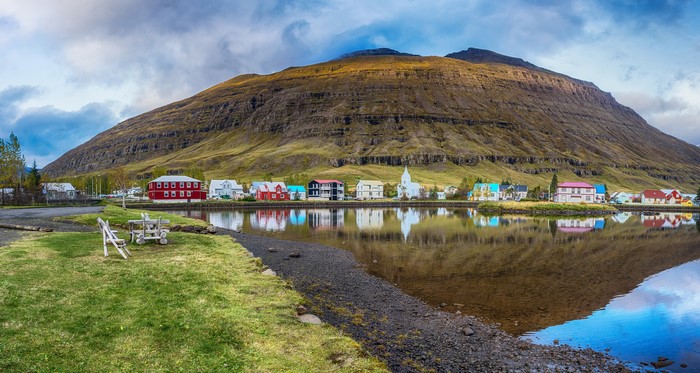 Icelandic village with colorful houses and mountain reflection
