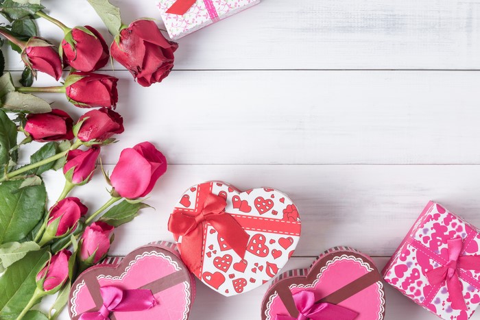 Red Roses and Heart-Shaped Gifts on White Wood