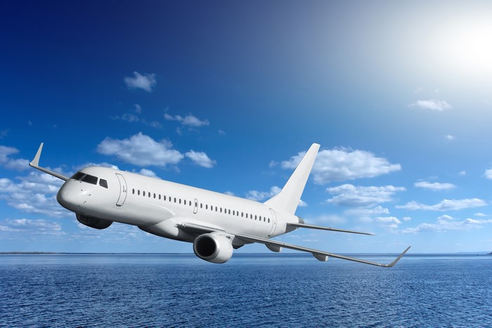Airplane flying over the sea under a blue sky
