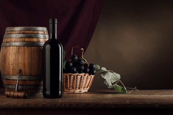 Wine bottle, barrel, grapes, and corkscrew