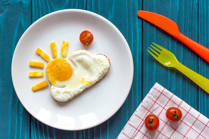 Fried egg sun with cheese and tomatoes on a plate