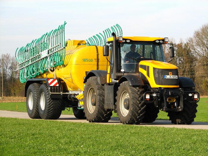 Yellow tractor with slurry tanker and applicator