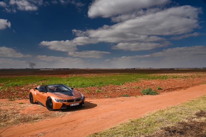 Orange BMW i8 Roadster on a dirt road