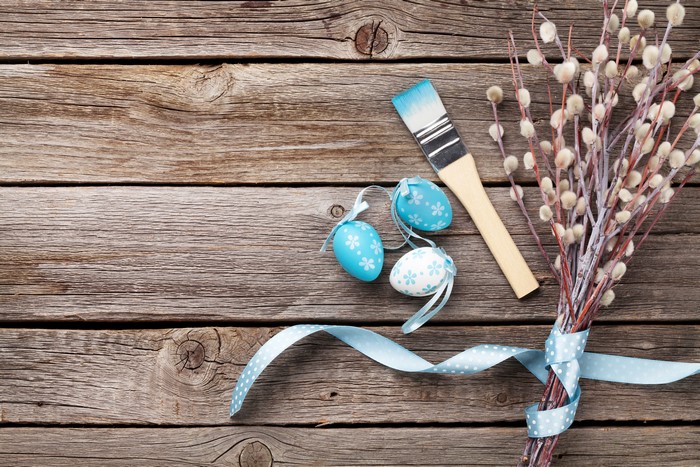 Easter eggs and paintbrush on wood planks