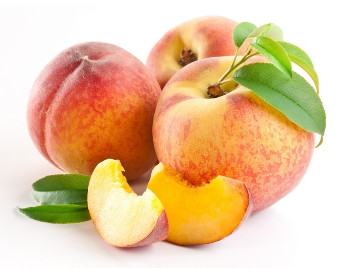 Peaches with leaves and slices on white background